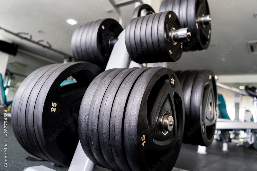 Sports equipment in gym Barbells of different weight on rack