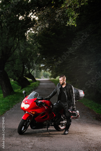 man in leather clothes on the sports bike outdoors