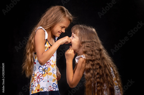 Girl pinched a hand on the nose of another girl
