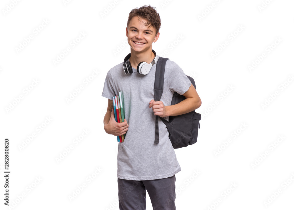 Happy teen boy with headphones and backpack holding books, isolated on ...