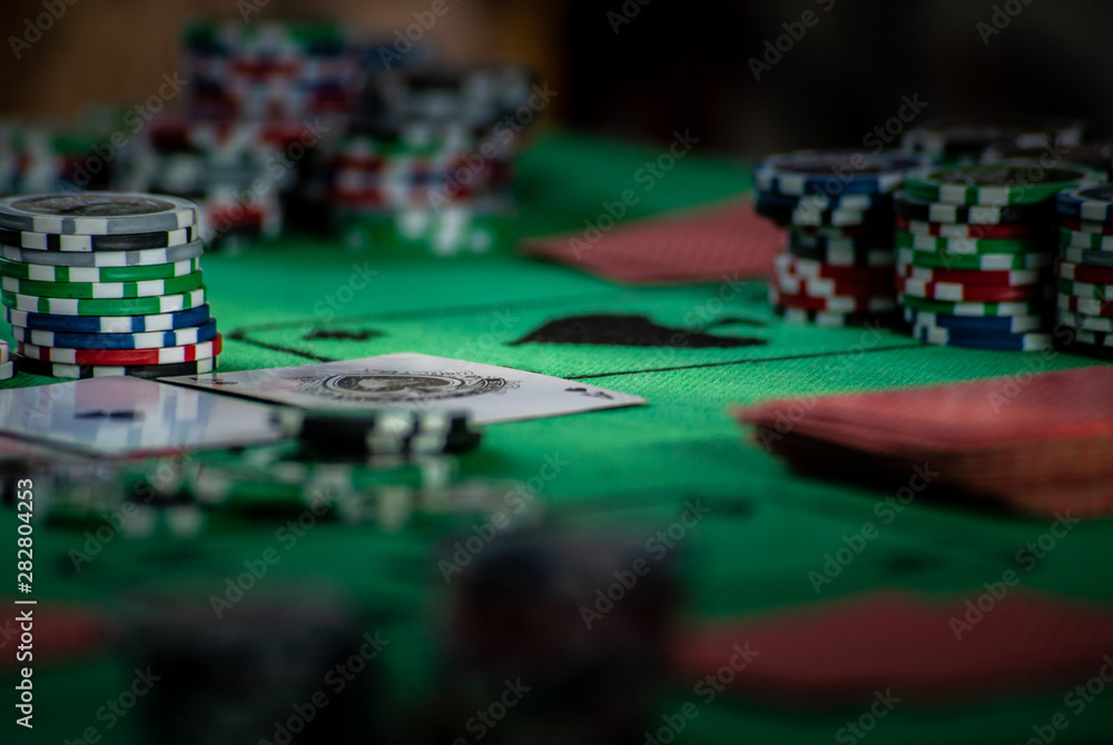 Obraz premium A poker table with casino chips and cards on greencloth, background with selective focus