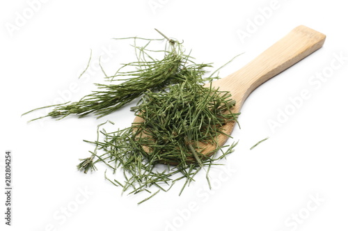Dry, chopped horsetail fern, (Equisetum arvense) with wooden spoon, isolated on white background photo