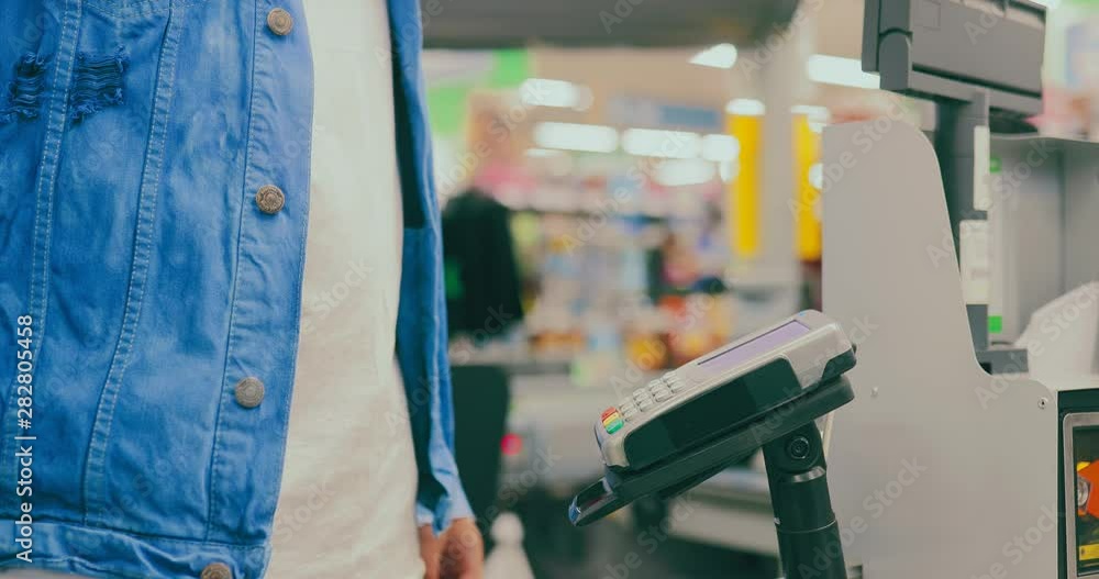 Buyer inserts a bank card into the point-of-sale terminal and enters a pin code. Payment by credit card. Close-up. Buyer inserts a bank card into the point-of-sale terminal and enters a pin code. Payment by credit card. Close-up.