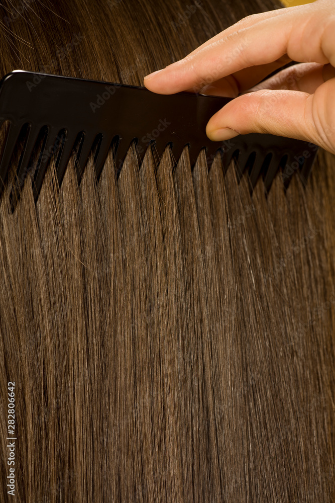 Fototapeta premium Closeup of woman combing her hair