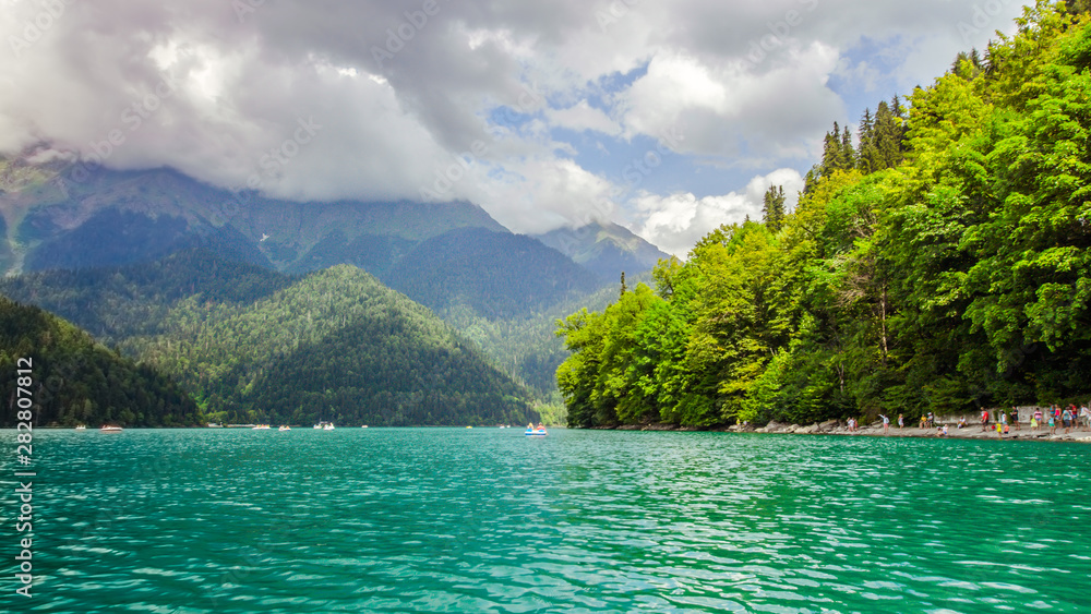 Natural landscape. Panorama view of the lake Small Ritsa. Trees reflecting in the blue from lapis lazuli water. Ritsa National Park, Abkhazia