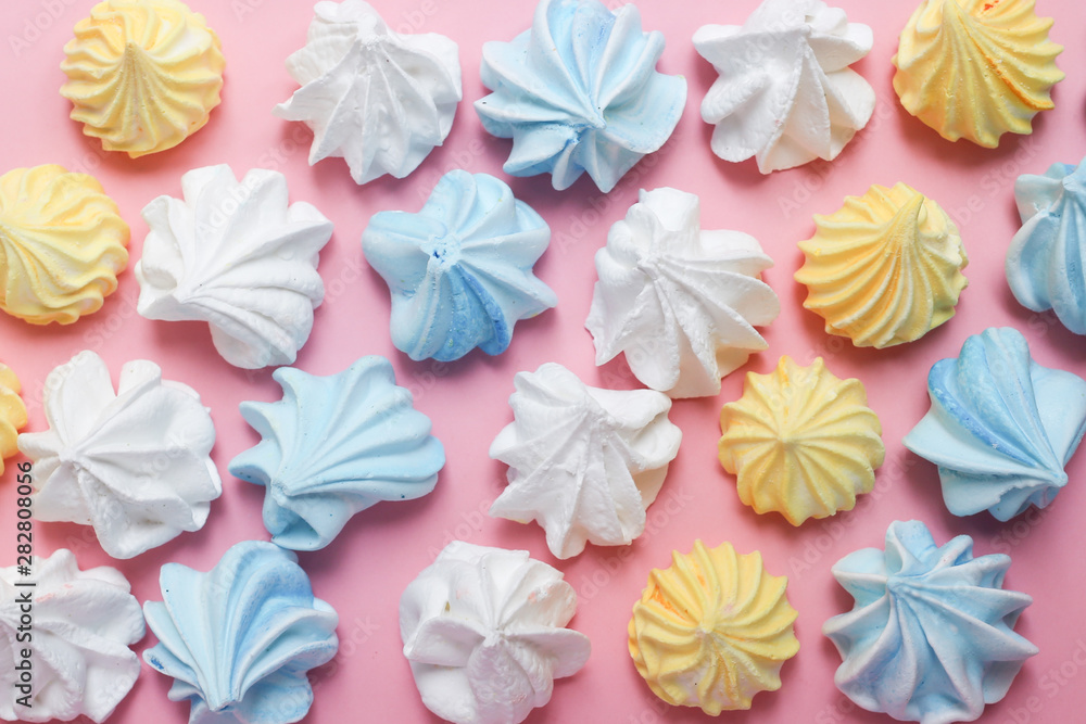 Fotografie Multicolored meringue on a pink pastel background