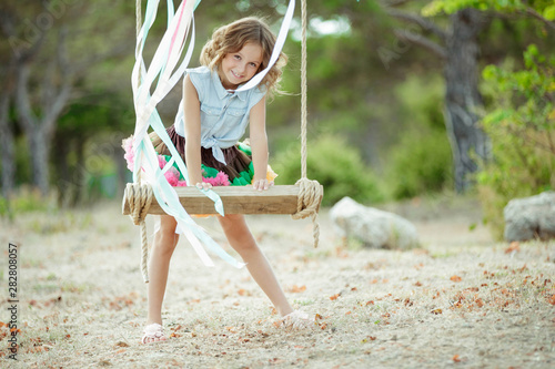 Little girl riding on a swing. 