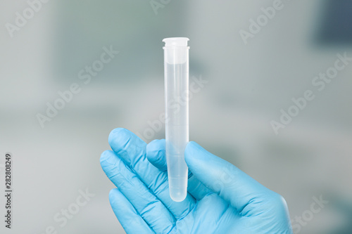 Photography Hand in medical gloves holds a medical probe container