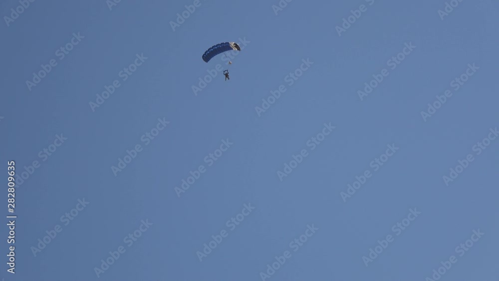4K. Ultra HD. Military paratroopers pulling from a plane. Engravings falling with the parachute deployed with a blue sky background. People in the air dropping by parachute. Adventure, aviation. 4K. Ultra HD. Military paratroopers pulling from a plane. Engravings falling with the parachute deployed with a blue sky background. People in the air dropping by parachute. Adventure, aviation.