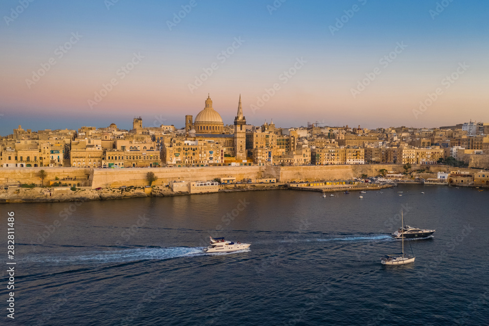Valletta - capital of Malta. Aerial view of Valletta Skyline in the evening, Sunset. Boats on the sea
