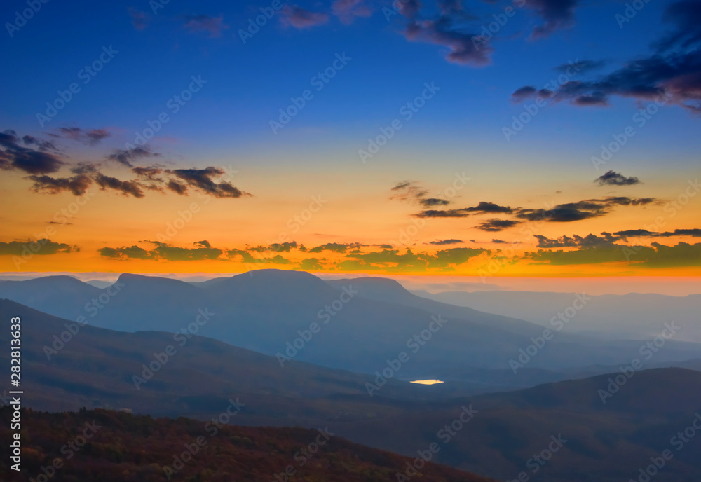 mountain silhouette in a blue mist at the dramatic twilight, natural outdoor background