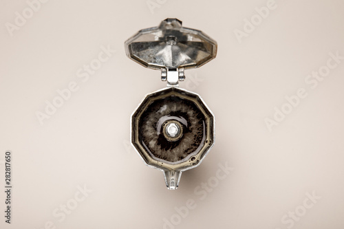 top view of opened metal coffee pot with fresh coffee on beige background