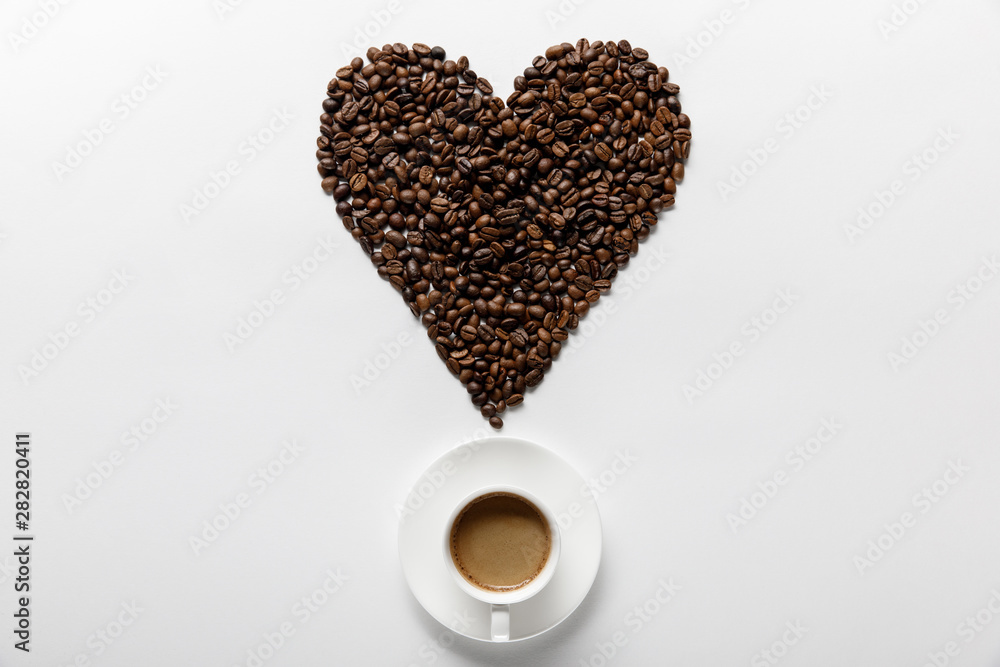 Φωτογραφία top view of delicious coffee in cup on saucer with heart made of coffee grains o