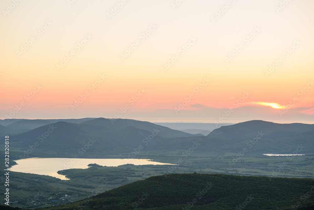 the view of two lakes from the height of the mountain, in the light of the setting sun, the clear cloudless sun. Spring view of the Crimea.