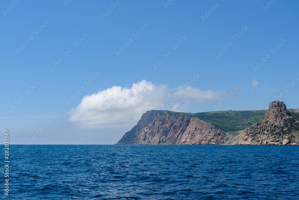 the endless expanses of the black sea, rich blue, on a bright sunny day with clouds in the sky, from the side of a pleasure boat in the black sea.
