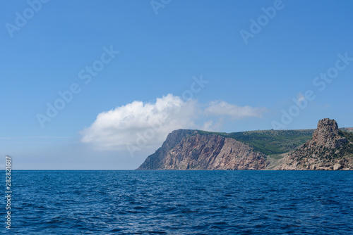 the endless expanses of the black sea, rich blue, on a bright sunny day with clouds in the sky, from the side of a pleasure boat in the black sea. © StockAleksey