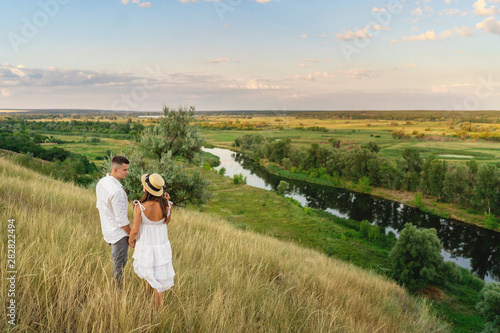 Authentic couple look to each other against the backdrop of a beautiful landscape. rear view