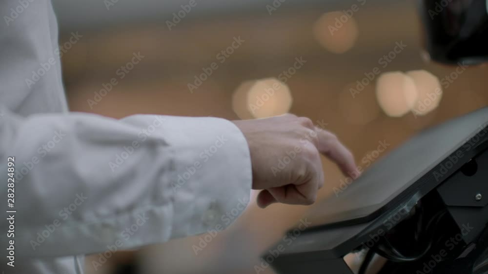 A man stands with a robot bot and asks him questions and asks for help by clicking on the screen on the robot body. A man stands with a robot bot and asks him questions and asks for help by clicking on the screen on the robot body.