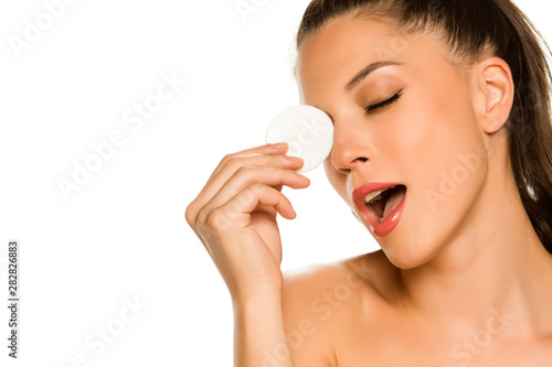 young beautiful woman posing with a sponge pad on the white background