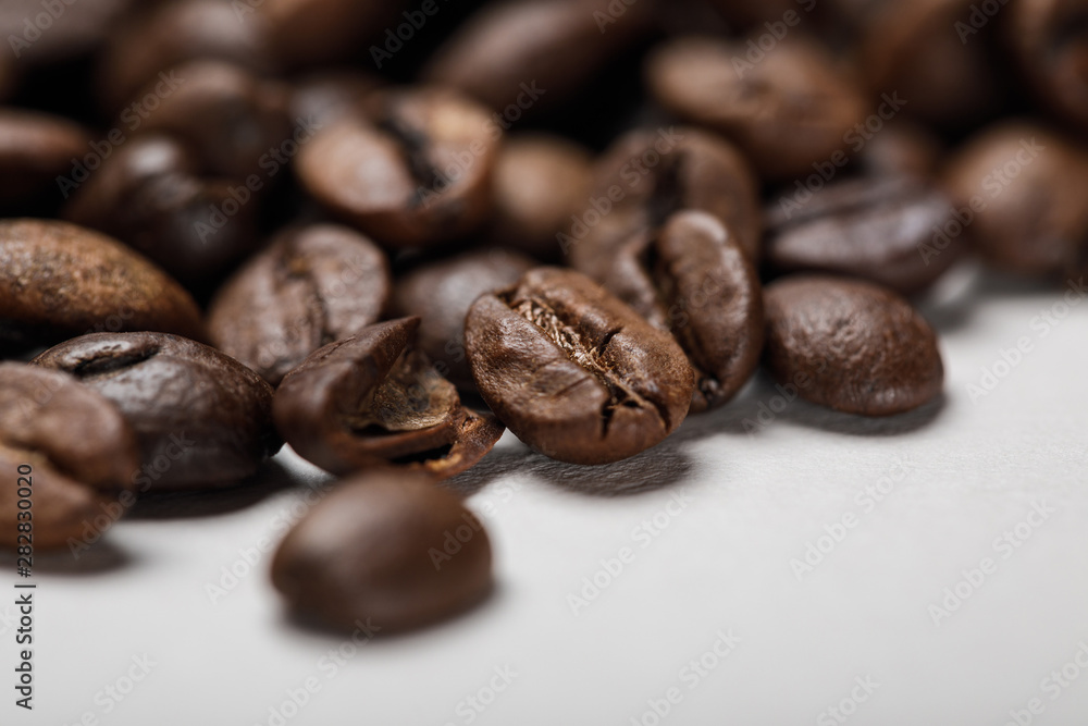 close up view of delicious fresh textured coffee grains on white surface close up view of delicious fresh textured coffee grains on white surface