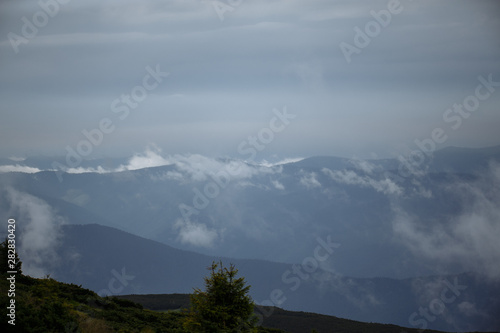 cloudy foggy morning in the mountains with beautiful panorama of the mountains © Andrii