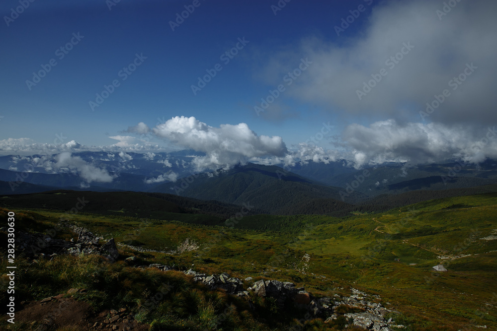 clouds soar over a beautiful view of a mountain range clouds soar over a beautiful view of a mountain range