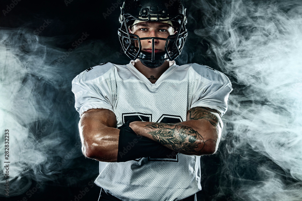American football player, sportsman in helmet on black background with  smoke. Sport and motivation wallpaper. Stock Photo | Adobe Stock