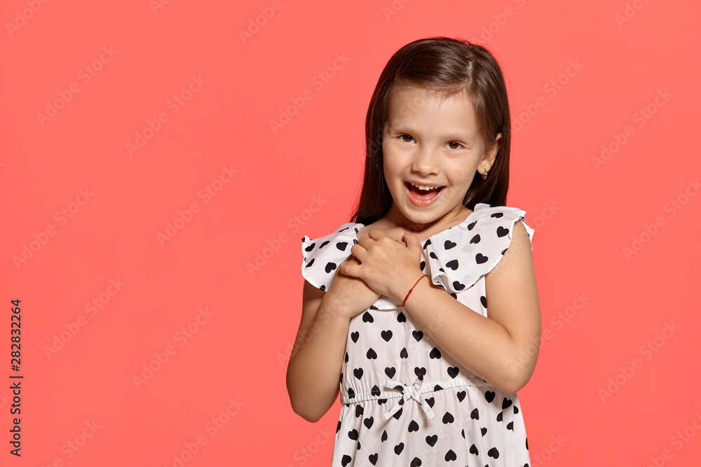 Close-up studio shot of beautiful brunette little girl posing against a pink background. Close-up studio shot of beautiful brunette little girl posing against a pink background.