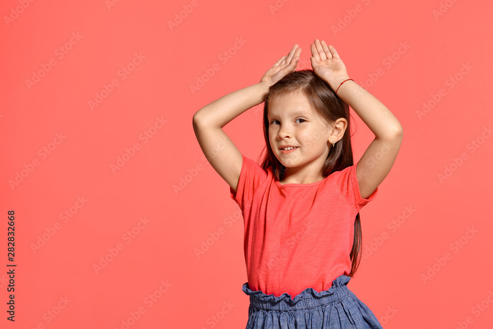 Close-up studio shot of beautiful brunette little girl posing against a blue background. Close-up studio shot of beautiful brunette little girl posing against a blue background.