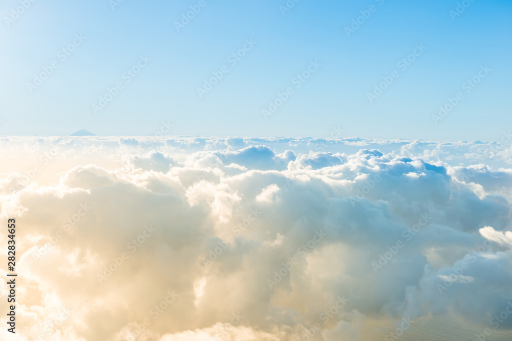 Airplane view of beautiful landscape with blue sky, gold colored clouds and ocean at sunny day