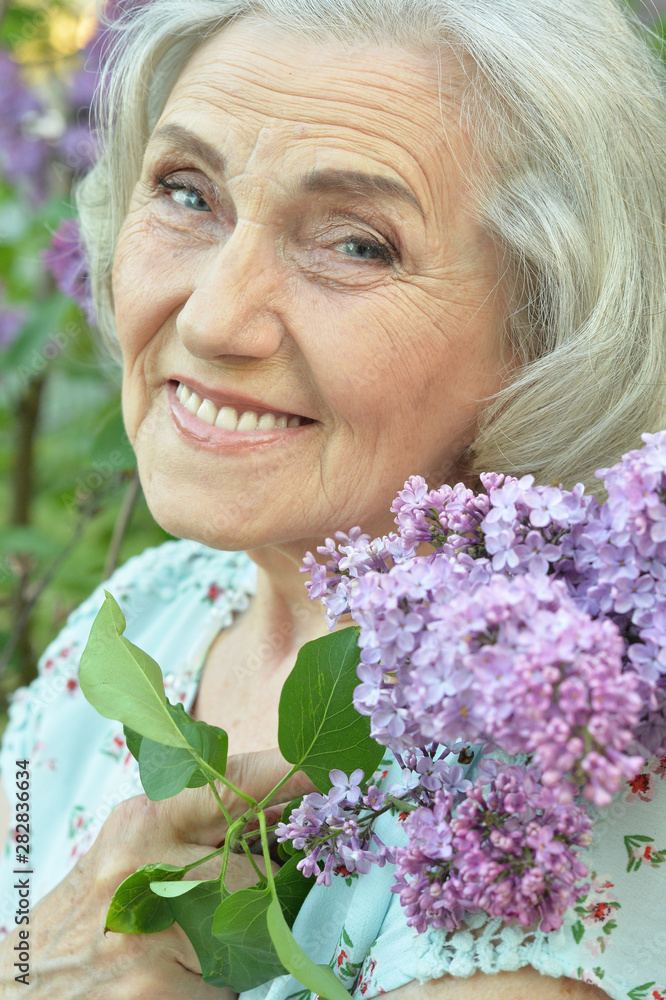 Portrait of happy senior beautiful woman with lilacs Portrait of happy senior beautiful woman with lilacs