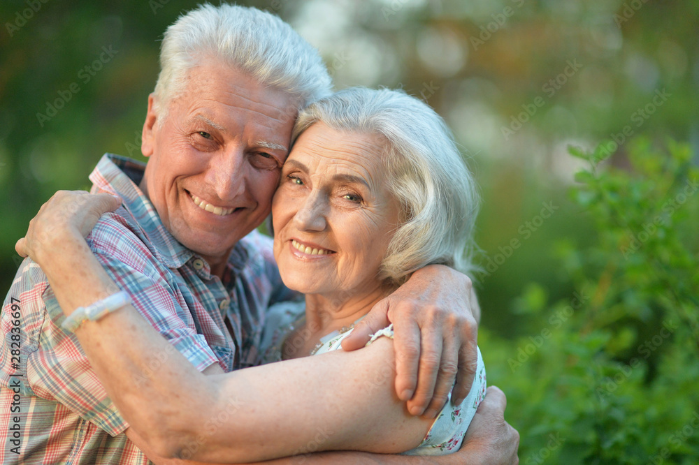 Beautiful senior couple hugging in the summer park Beautiful senior couple hugging in the summer park