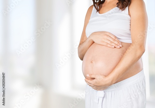 Free Download Pregnant young woman in white t shirt on  background - GFXLoad