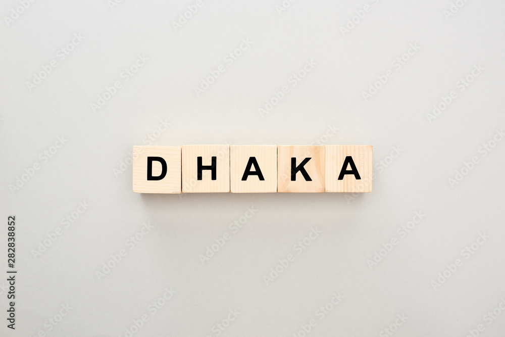 top view of wooden blocks with Dhaka lettering on grey background top view of wooden blocks with Dhaka lettering on grey background