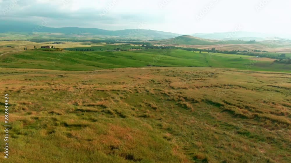 Drone flying over beautiful lake and green farmland on summer day. Observing amazing landscape panorama of Val d'Orcia nature reserve near Pienza city. Drone flying over beautiful lake and green farmland on summer day. Observing amazing landscape panorama of Val d'Orcia nature reserve near Pienza city.