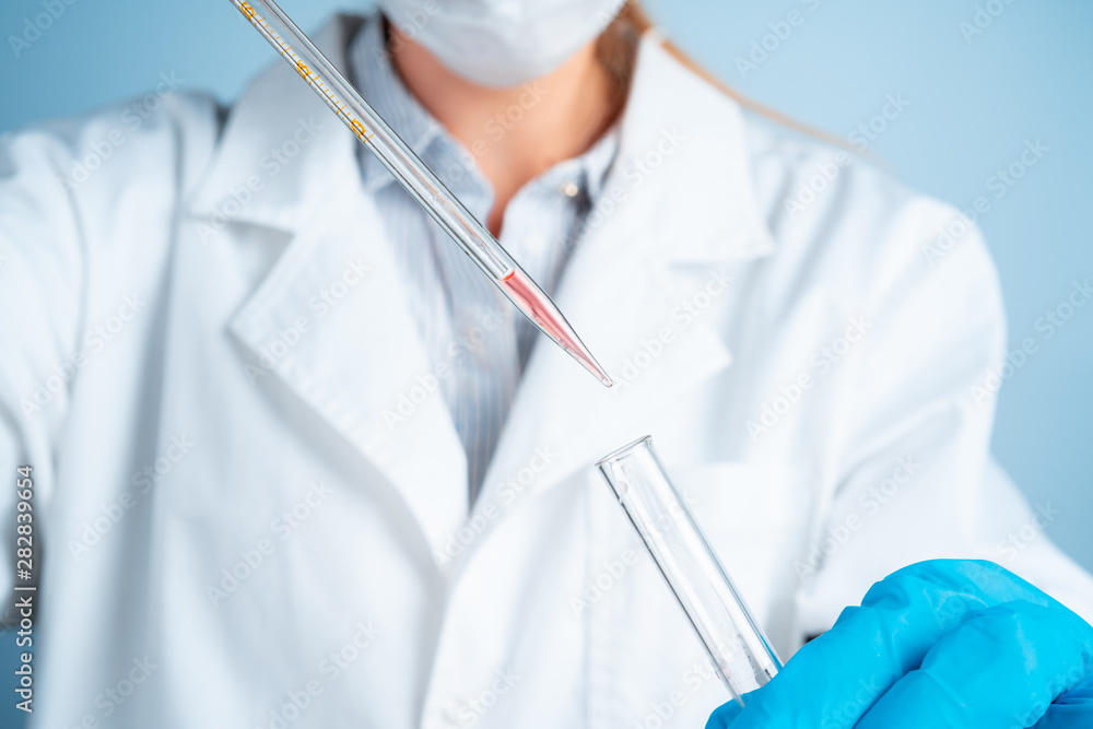 Young scientist with test tube making research in clinical laboratory.Professional science specialist at work. Young scientist with test tube making research in clinical laboratory.Professional science specialist at work.