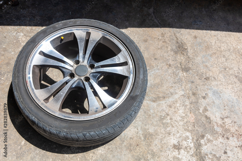 One car wheel with tyre on ground