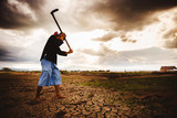 Desperate Farmer working on dry ground with hoe. Global warming crisis,  Economic crisis concept