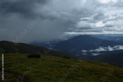 Fototapeta Naklejka Na Ścianę i Meble -  rain high in the mountains floods half the panorama of the mountains