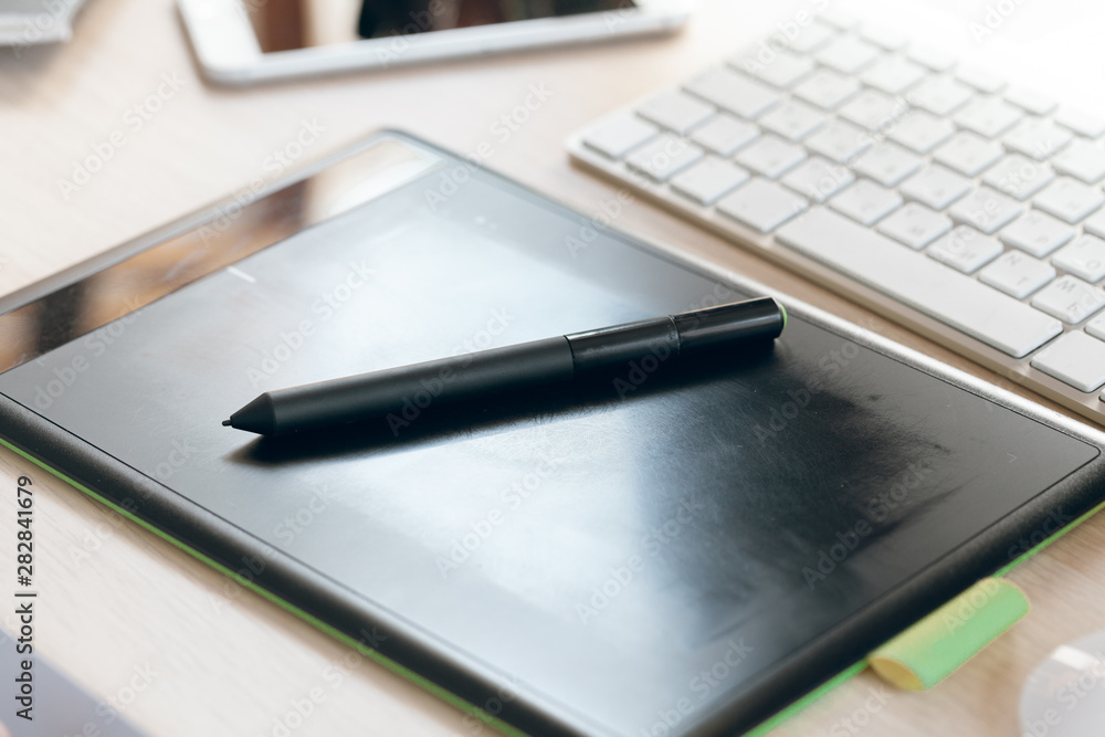 Close up of graphic tablet with pen for illustrators and designers in an office Close up of graphic tablet with pen for illustrators and designers in an office