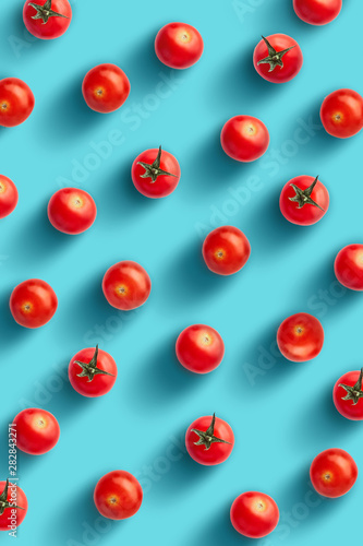 Cherry tomatoes on colored background. Pattern of cherry tomatoes. Vegans concept. Composition of tomatoes