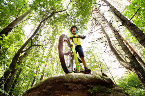 Young boy riding in the wild forest.