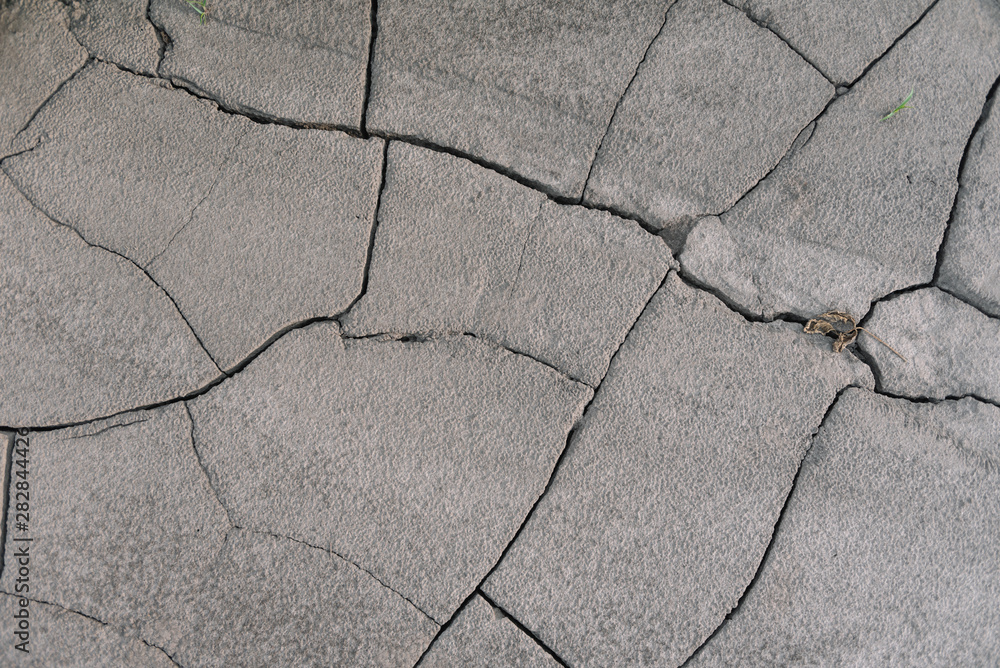Obraz premium Grey cracked earth ground from drought disaster cause from weather change. The global warming and greenhouse effect cause of agricultural production is reduced.