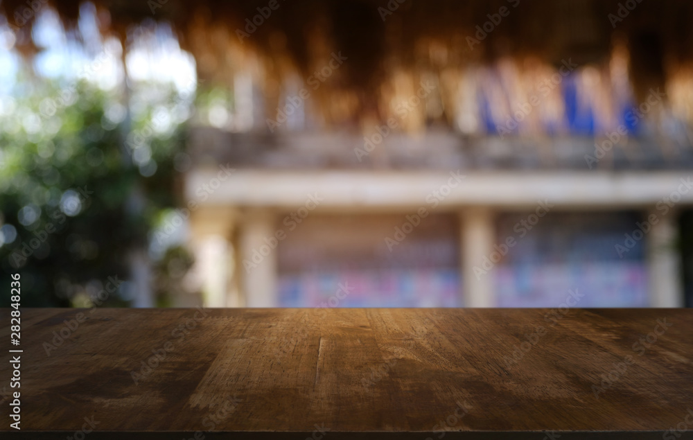 Empty dark wooden table in front of abstract blurred bokeh background of restaurant . can be used for display or montage your products.Mock up for space.