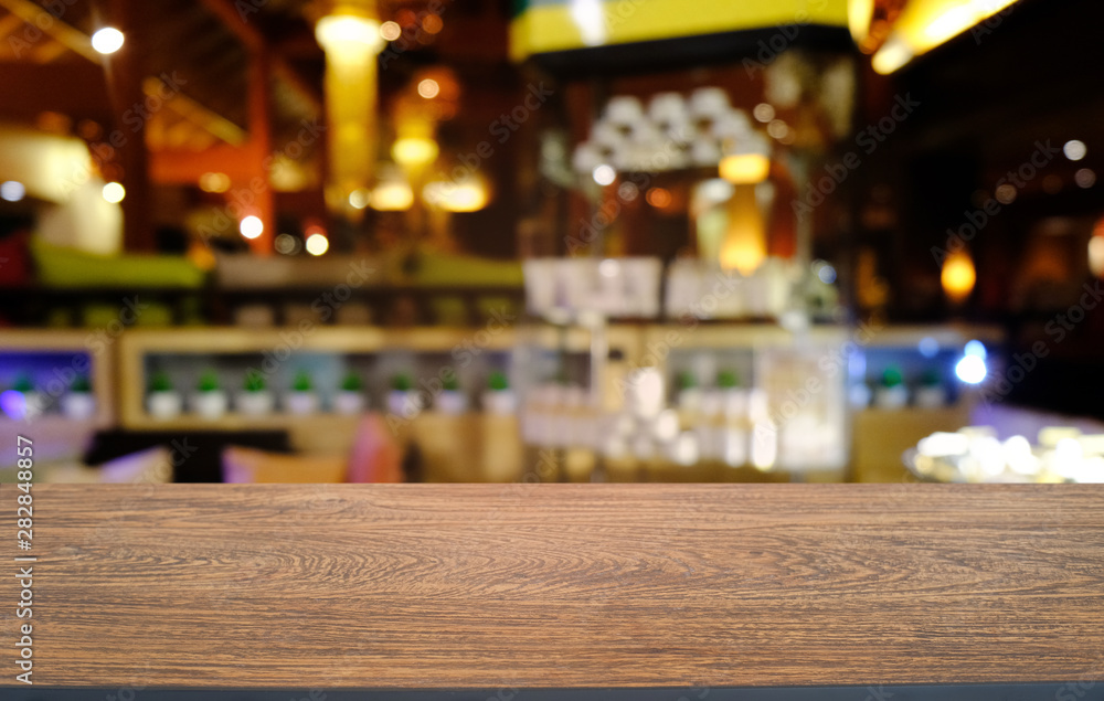 Empty dark wooden table in front of abstract blurred bokeh background of restaurant . can be used for display or montage your products.Mock up for space.