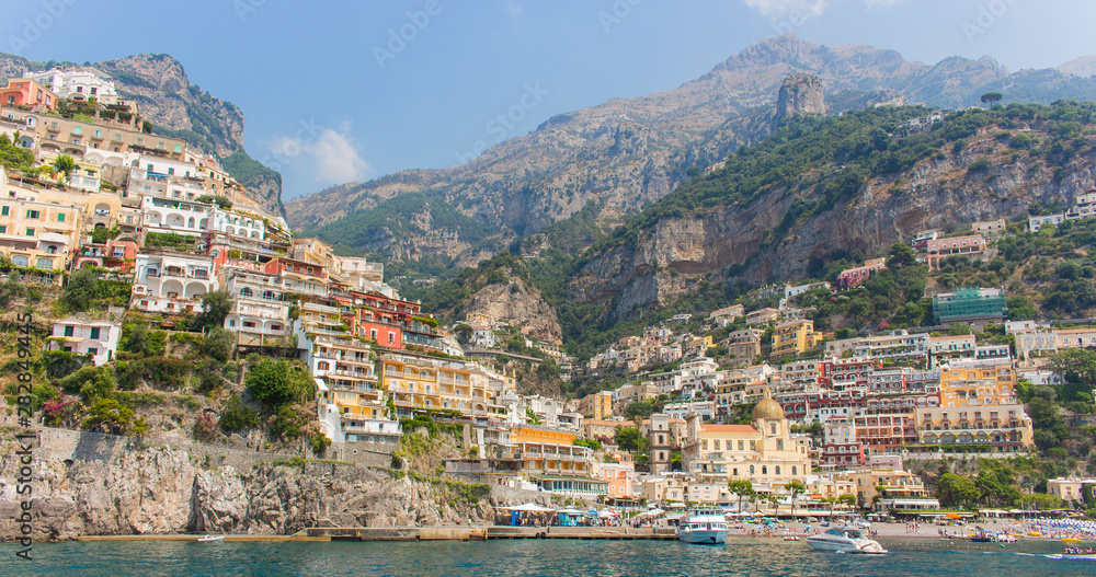 Positano village built on the cliff of the mountain, overhanging the Tyrrhenian sea. The town is located on the Amalfi Coast, in Italy (Campania). Colorful houses and beach a sunny summer day. – Image