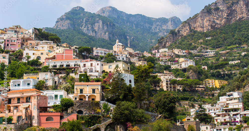 Colorful houses, church and blue sky of Positano, in Italy (Campania). This town is built on the cliff of the mountain, along the Amalfi Coast. Shot taken a sunny summer day. – Image