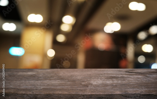 Empty dark wooden table in front of abstract blurred bokeh background of restaurant . can be used for display or montage your products.Mock up for space.