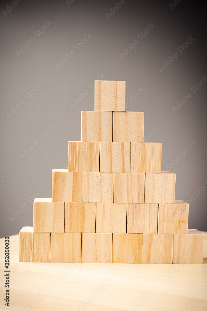 Wooden blocks stacked against grey background Wooden blocks stacked against grey background