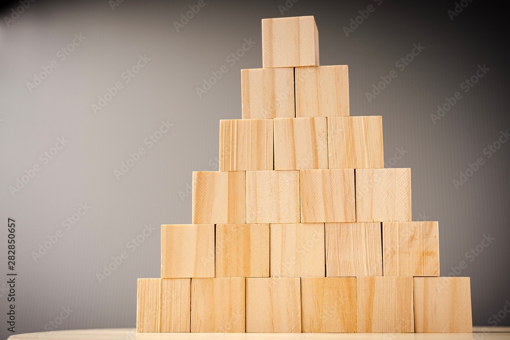 Wooden blocks stacked against grey background Wooden blocks stacked against grey background